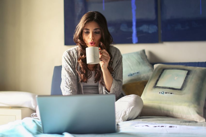 woman-having-coffee-and-using-laptop-in-bed-4050389-(1).jpg